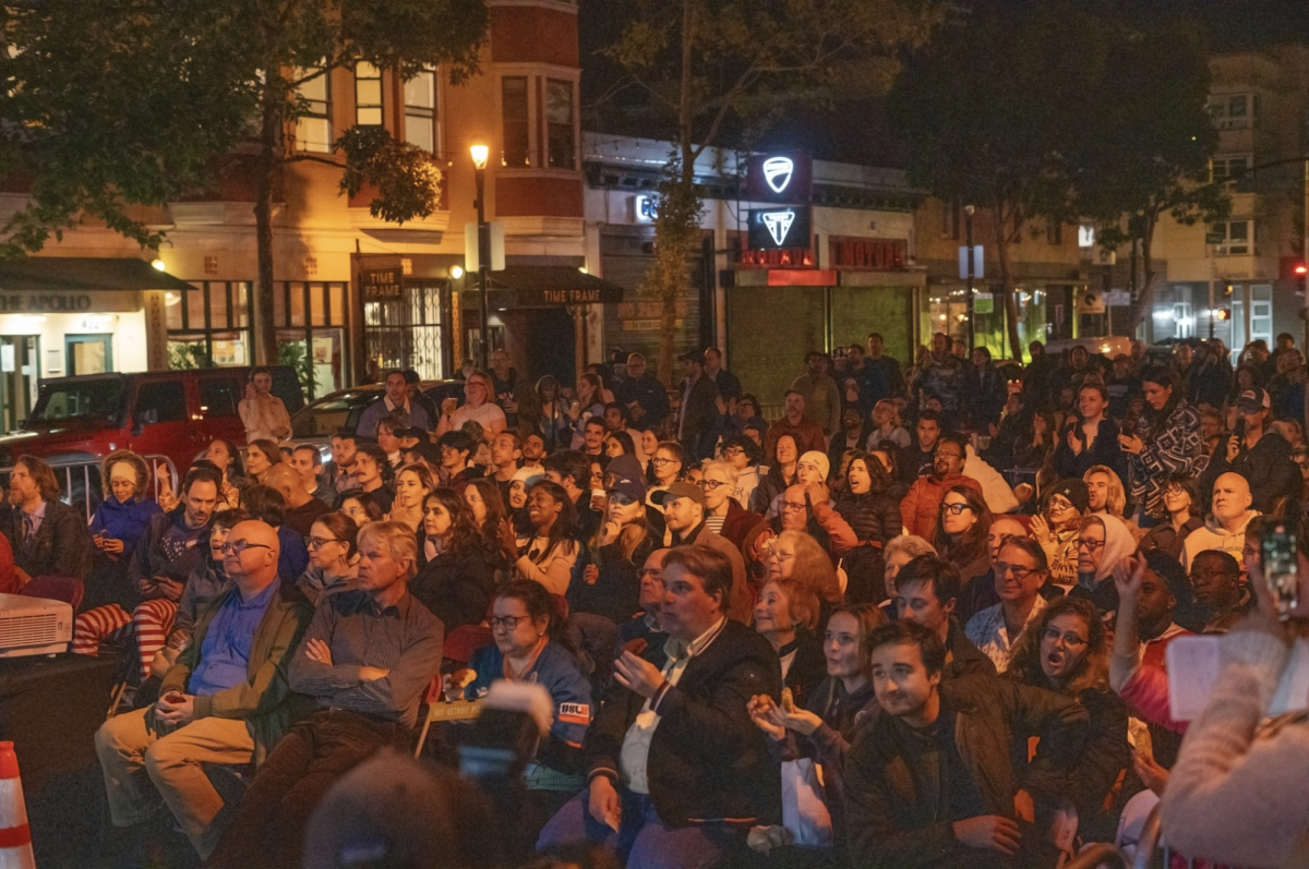 People sit patiently for the next update during a 2024 Presidential election watch party outside of Manny’s cafe on Valencia Street in the Mission District on Nov. 5, 2024. (Sean Young / Golden Gate Xpress)